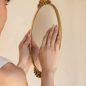 Detailed view of a gold V-shaped ring with a small gemstone on a model hand