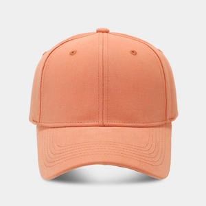 Detail of orange canvas baseball cap featuring six-panel structure and embroidered eyelets