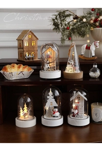 Detail of illuminated wooden and glass Christmas scenes with Santa and Reindeer models