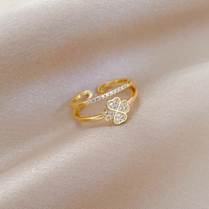 Detailed macro shot of a gold clover ring with diamonds on champagne silk background