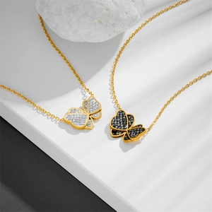 Elegant gold butterfly necklaces with clear and black crystals on professional display