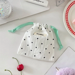 Dettaglio della borsa in cotone bianco con cuori neri e cordoncino verde menta