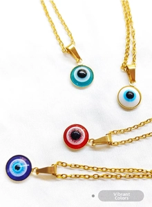 Close-up of four colorful evil eye pendants in blue, white, and red on gold metal chains