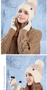Detail of warm winter knit hat with pompom and touchscreen gloves in beige and khaki