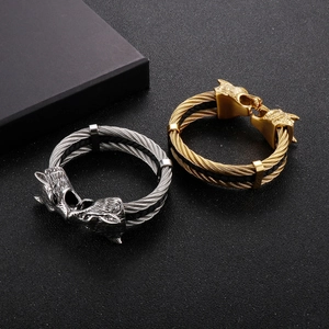 Detailed shot of two wolf head cable bracelets in gold and silver stainless steel