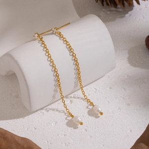 Detail of long gold chain tassel earrings with white pearls and sparkling cubic zirconia
