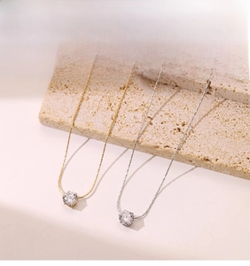 Close-up of gold and silver necklaces with round cubic zirconia on stone background