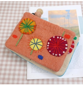 Detail of wool felt coin purses with hand-embroidered flowers in multiple colors