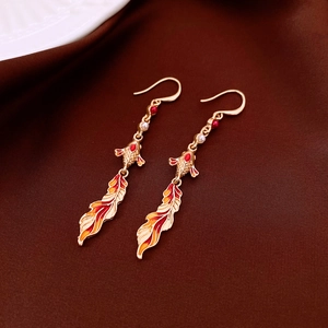 Detailed close-up of gold koi fish earrings with red enamel and white pearl drop