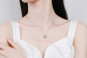 Close-up of geometric square moissanite pendant on a silver necklace worn by a model
