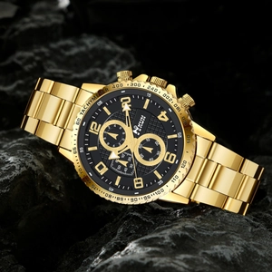 Detail of golden quartz watch with black dial and three-subdial design on dark rock