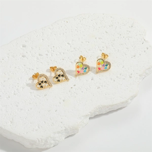 Elegant gold heart earrings with colorful enamel patterns and sparkling crystals on stone