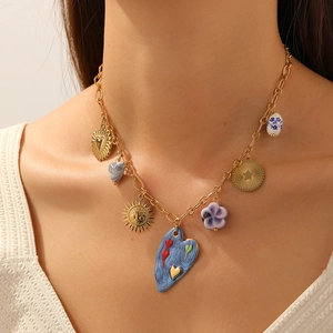Gold-plated stainless steel necklace with enamel heart and flower pendants on a model