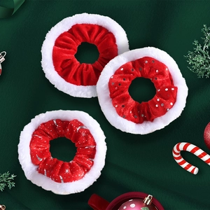 Detailed view of red velvet and white plush Christmas scrunchies with silver patterns