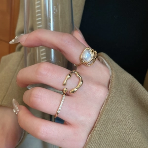 Close-up of stacked gold heart rings with diamonds and opals on female hand