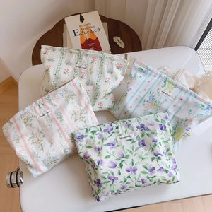 Detail of four floral cotton makeup bags with zippers and simple wish woven labels