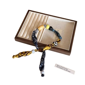 Collier bohème en tissu avec perles en bois et pendentif cœur léopard sur plateau en bois