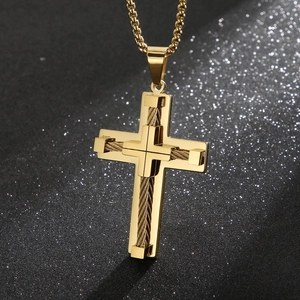 Macro detail of gold cross pendant featuring layered rope texture on stainless steel