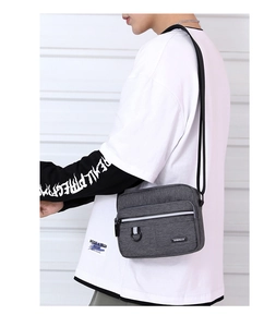 Detail of dark grey water-resistant oxford fabric crossbody bag showing texture and D-ring
