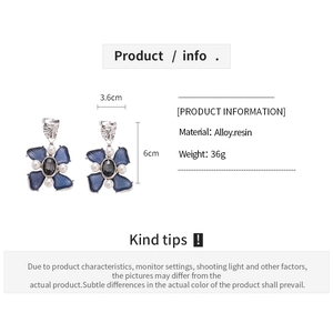 Detail view of blue flower resin earrings with dimensions of 3.6cm by 6cm and silver needles