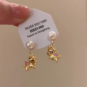 Detail of 925 silver unicorn pearl earrings featuring gold finish and pink enamel wings