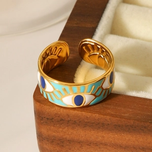 Macro detail of gold evil eye ring with blue enamel on a premium wooden jewelry box