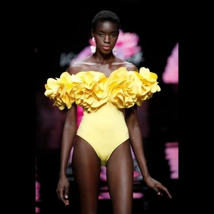 Close-up of yellow off-shoulder swimsuit featuring a large 3D floral ruffled design
