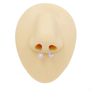 Detail showing pink flower and butterfly charms on a stainless steel septum horseshoe ring