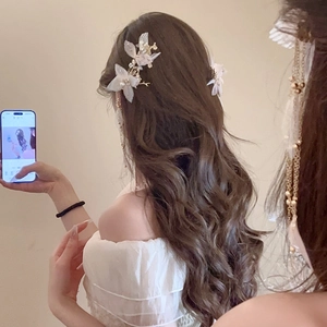 Détail de pinces à cheveux fleurs 3D blanches avec perles et élégantes chaînes à pompons