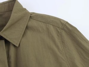 Detail of olive green shirt collar and shoulder stitching with textured fabric