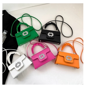 Macro shot of stylish rhinestone square buckles and pleated handles on mini handbags