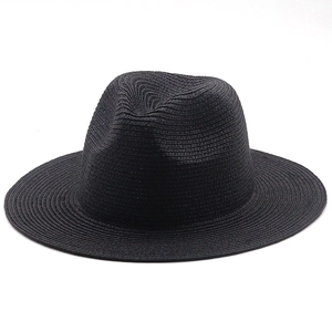 Close-up of a black straw sun hat with wide brim showing detailed woven texture and fedora crown
