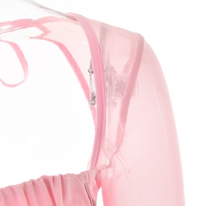 Détail du haut en maille rose montrant les coutures d'épaule et la texture du col