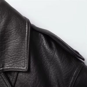 Close-up of black faux leather jacket featuring lapel collar and shoulder strap details