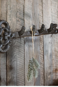 Close-up of vintage cast iron key-shaped wall hook with floral patterns on rustic wood