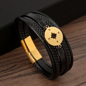 Close-up of men's leather bracelet with golden magnetic clasp and compass engraving