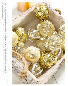 Detail of champagne gold Christmas ornaments with glitter and mesh textures in a wooden box