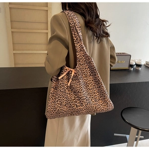 Close-up of leopard print canvas tote bag with pink bow ribbon on shoulder strap