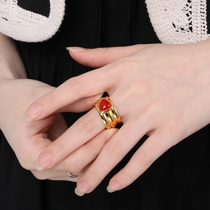 Detailed view of irregular gold band ring featuring a red triangular turquoise stone inlay