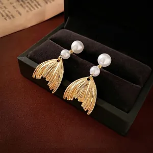 Elegant fishtail fringe pearl earrings in gold finish presented on a luxury jewelry box