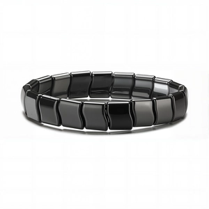 Bracelet magnétique en hématite noire polie avec perles irrégulières ondulées sur fond blanc