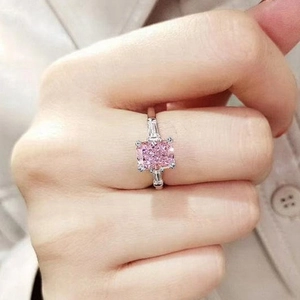 Detail of pink square-cut gemstone ring with side baguette stones on model hand