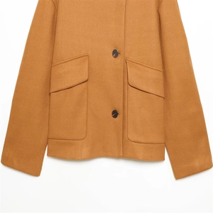 Detailed close-up of camel wool jacket showing large utility pockets and resin buttons