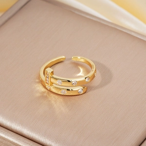 Detailed close-up of golden double-layered open ring with sparkling cubic zirconia stones