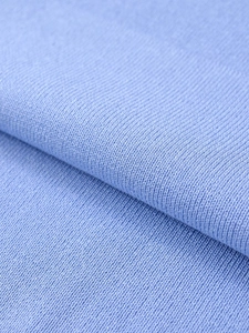 Close-up of soft light blue knit fabric texture showing high-quality fine material details