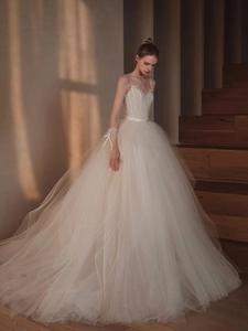 Detailed lace bodice with thin straps and ivory tulle skirt on wedding gown