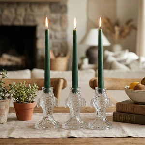 Trois bougeoirs en verre en forme de poisson avec bougies vertes pour décor de table