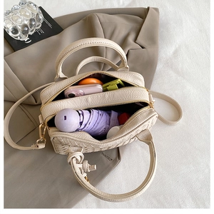 Interior view of beige woven Boston bag showing storage space for umbrella and phone