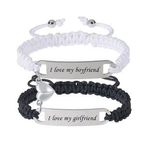 Detail of magnetic heart charms and engraved lettering on braided couple bracelets