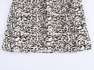 Close-up of the black and white leopard print faux fur texture on the coat hemline